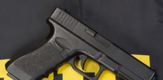 Black handgun on a yellow and black background.