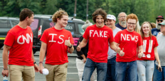 Group wearing CNN is Fake News shirts thumbs up