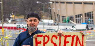 Man holding Epstein didn't kill himself 2020 sign.