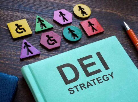 DEI strategy book with inclusive wooden symbols.