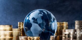 Glass globe surrounded by stacks of gold coins.