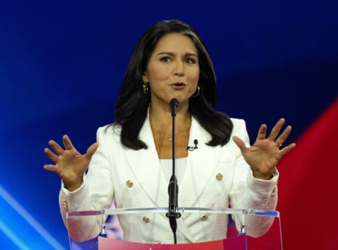 Person speaking at a podium with hands raised