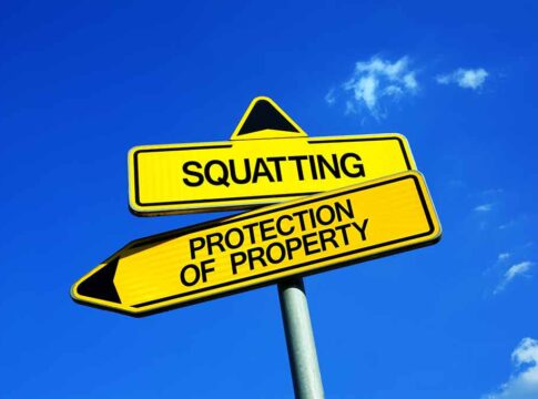 Two conflicting road signs: Squatting and Protection of Property.