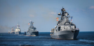 Several naval warships sailing in the ocean.