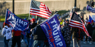 People holding Trump flags and American flags rallying