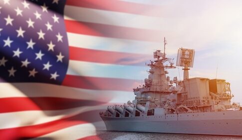 US flag and navy warship in the background.