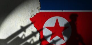 North Korean flag with soldier silhouette in shadow.