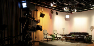 Empty TV studio set with chairs and a sofa.