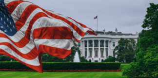 U.S. flag waving in front of the White House.