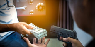 Person giving money while threatened with a gun.