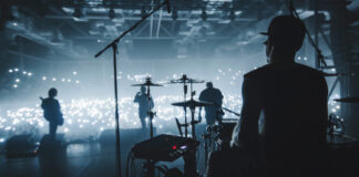 Band performing on stage with illuminated audience.