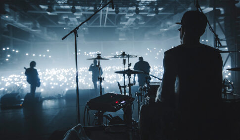 Band performing on stage with illuminated audience.