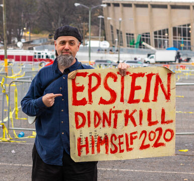 Man holding Epstein didn't kill himself 2020 sign.