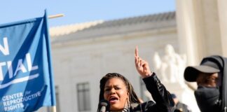A woman speaks passionately at a public rally.