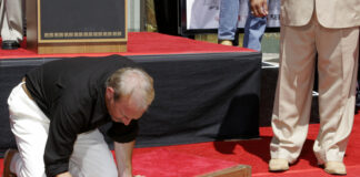 Man writing in cement at Hollywood Walk of Fame.