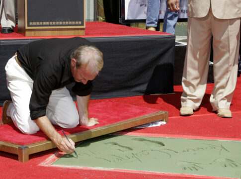 Man writing in cement at Hollywood Walk of Fame.
