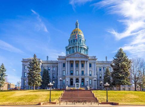 State capitol building with golden dome under blue sky.