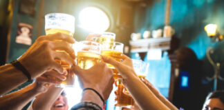 People toasting with beer in a bar.