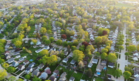 Aerial view of a suburban neighborhood with green trees.