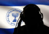 Silhouette with headphones, Mossad emblem in background.