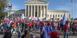 People gathered with flags in front of building