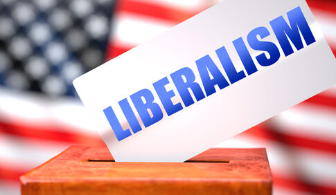 Ballot box with Liberalism card, American flag background.