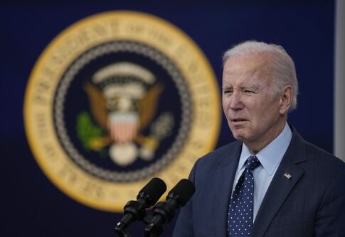 A man speaking in front of presidential seal.