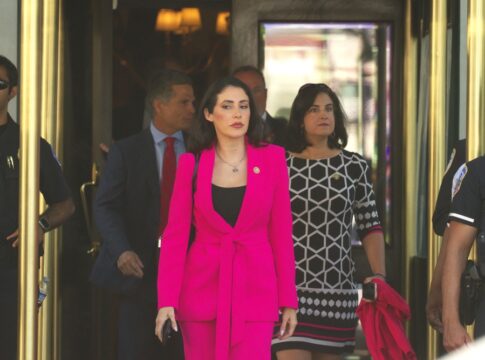 People exiting a building with security guards present
