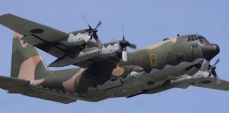 Camouflage military aircraft flying in the sky.