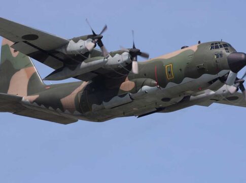 Camouflage military aircraft flying in the sky.