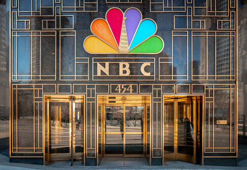 NBC building entrance with colorful peacock logo.