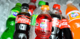 Assorted soda bottles including Coca-Cola and Fanta on ice.