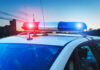 Police car with lights flashing at dusk.