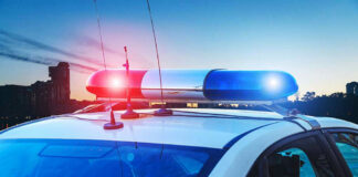 Police car with lights flashing at dusk.