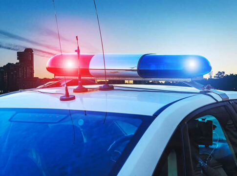 Police car with lights flashing at dusk.