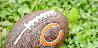Football with Chicago Bears logo on grass.