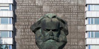 Bust of Karl Marx with multilingual backdrop.
