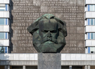 Bust of Karl Marx with multilingual backdrop.