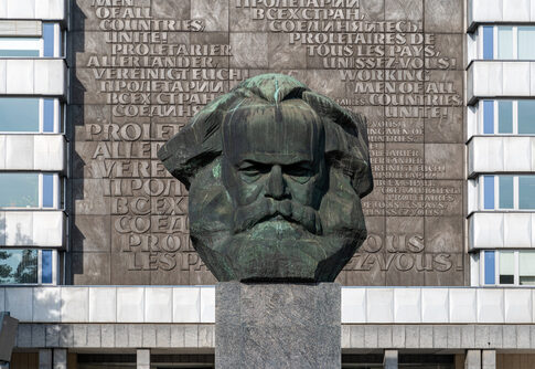 Bust of Karl Marx with multilingual backdrop.