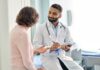 Doctor talking to a patient in an examination room.