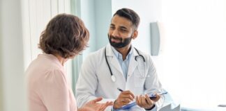Doctor talking to a patient in an examination room.