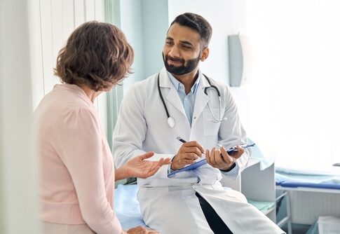 Doctor talking to a patient in an examination room.