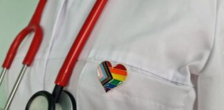 Doctor's coat with stethoscope and rainbow heart badge.