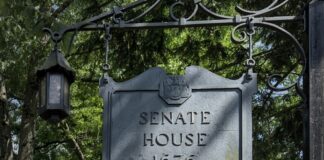 Historic Senate House sign from 1676 surrounded by trees