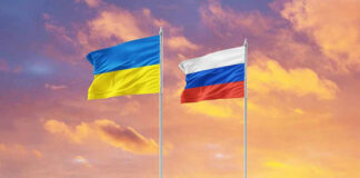 Ukrainian and Russian flags against a sunset sky.