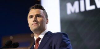 A man in a suit speaking at a podium during a conference