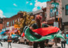 Person holding a flag on a busy street.