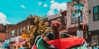Person holding a flag on a busy street.