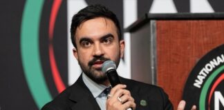 A man speaking into a microphone at a conference