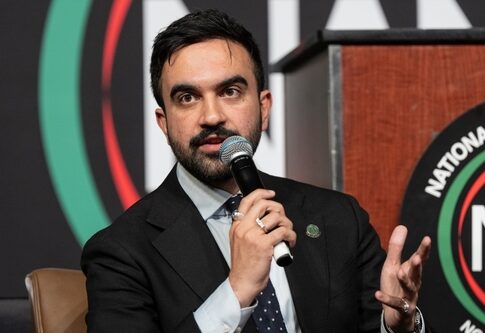 A man speaking into a microphone at a conference